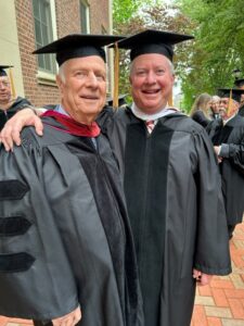 Mark '55 and Michael '82 Weisburger at Lafayette's 188th Commencement are standing in academic regalia with their arms around each other. 