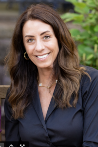 Photo of Fran Della Badia '91. Fran is wearing a black shirt and is smiling at the camera.
