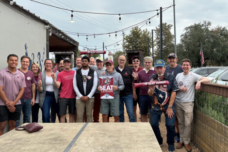 A group of alumni stand outside.
