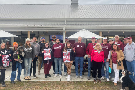 A group of alumni stand outside.