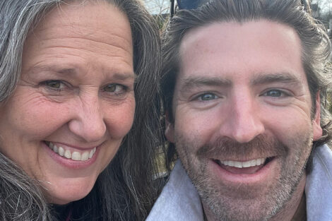 Two alumni are smiling.