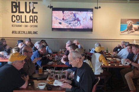 A group of alumni are seated in a restaurant.