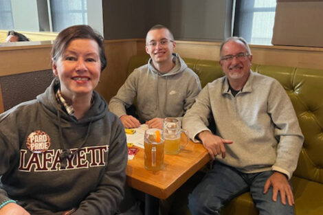 Three individuals are seated at a table.