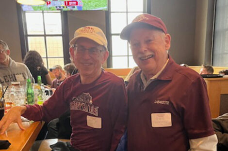 Two men are seated at a bar.