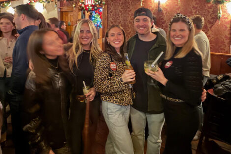 Alumni are standing at a bar