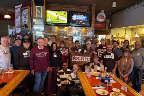 A group of alumni stand at a bar.