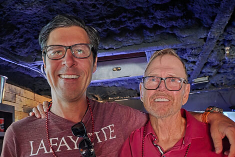 Two men smile at the camera