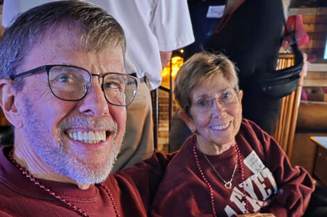 A man and woman smile at the camera