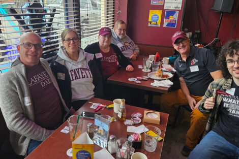 A group of alumni are seated at a table.