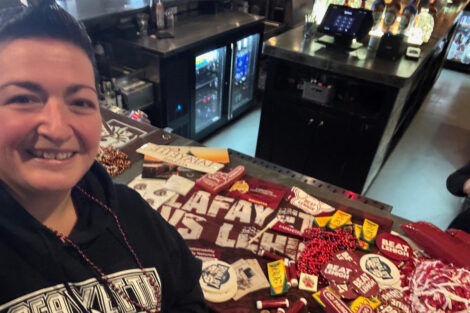 Alumna stands near Lafayette swag.